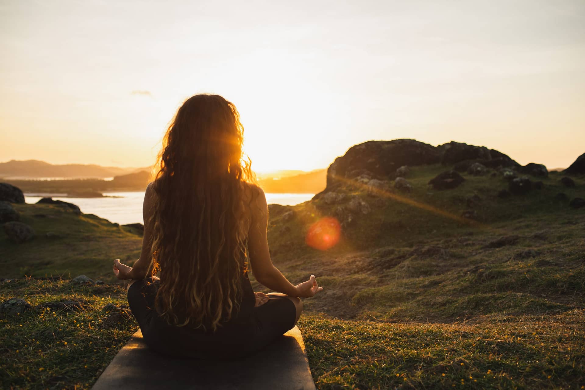 woman meditating yoga alone at sunrise mountains 2021 12 09 08 24 09 utc scaled